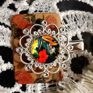 Single silver hair clip with tropical floral cabachon.